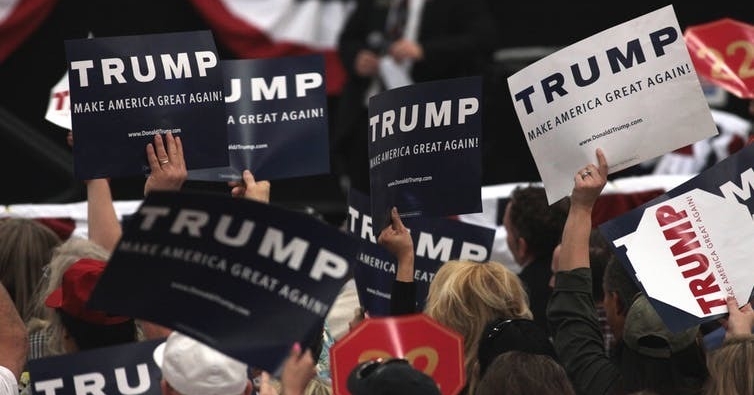 Supporters of President Donald Trump during a campaign rally. Supporters of President Donald Trump wave campaign signs.