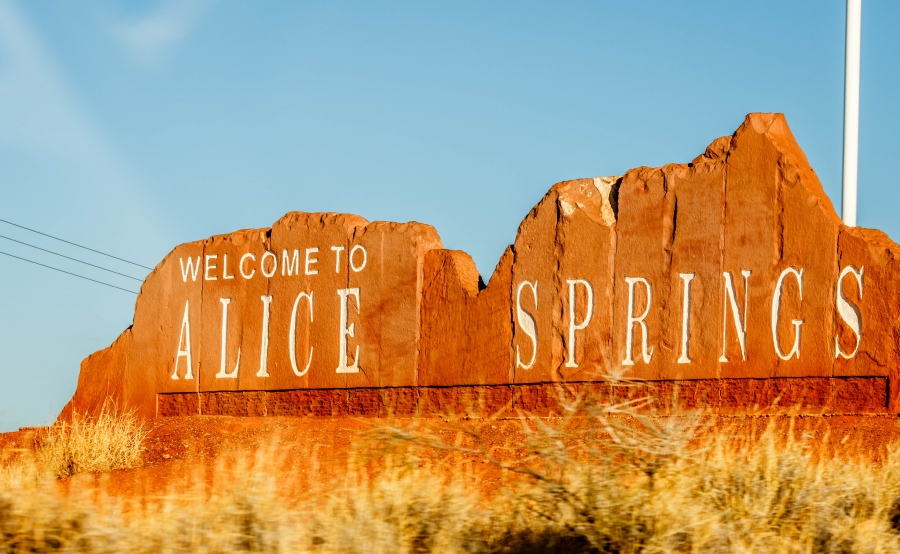 Alice Springs is the central city in what is known as Australia's "Red Center," denoted for it's red rock and red earth. A stone sign for Alice Springs is shown in the shape of the mountain skyline.