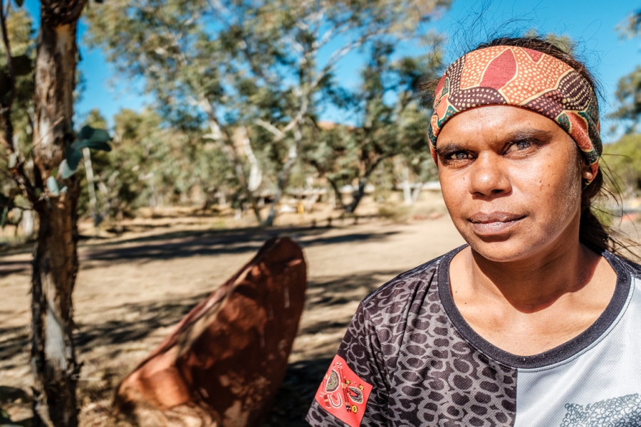 Shirleen Campbell is an organizer with The Tangentyere Women's Family Safety Group — a family violence prevention group in Alice Springs. She experienced domestic violence and together with other women in her family helped her husband turn around his beha Shirleen Campbell is shown in a portrait photo wearing a colorful headband.
