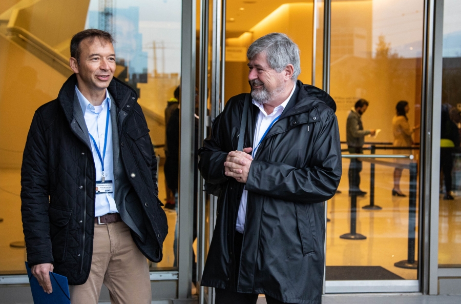 Two men stand outside a government building.