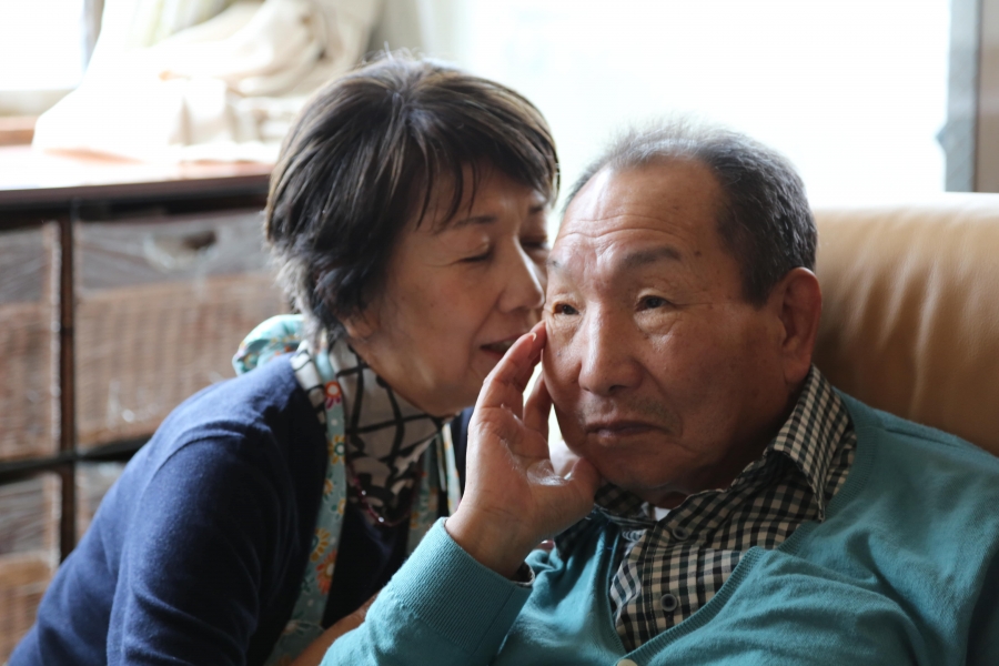 a woman whispers into a man's ear