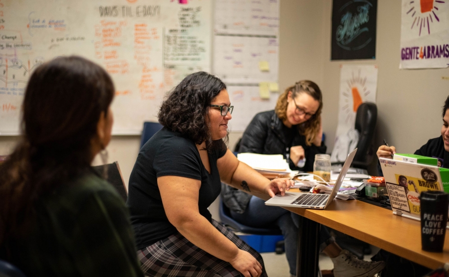 Tania Unzueta holds an election debrief with her colleagues at the Georgia Latino Alliance for Human Rights. Tania Unzueta is shown seated with her colleagues at a table at the Georgia Latino Alliance for Human Rights.
