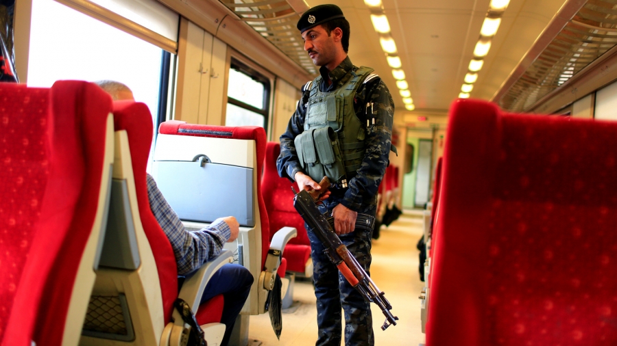 An Iraqi policeman stands guard in a passenger cabin of the train on the way to Fallujah after leaving Baghdad Railway Station, the newly resurrected service to the city, in Baghdad, Iraq, Nov. 7, 2018. An Iraqi policeman stands guard in a passenger cabin with red seats on the way to Fallujah.