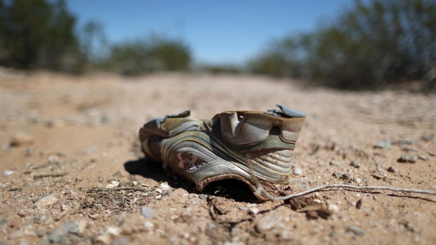 A shoe likely left by a migrant crossing the desert is seen in Pima County, Arizona, Sept. 12, 2018. A worn shoe in the desert.
