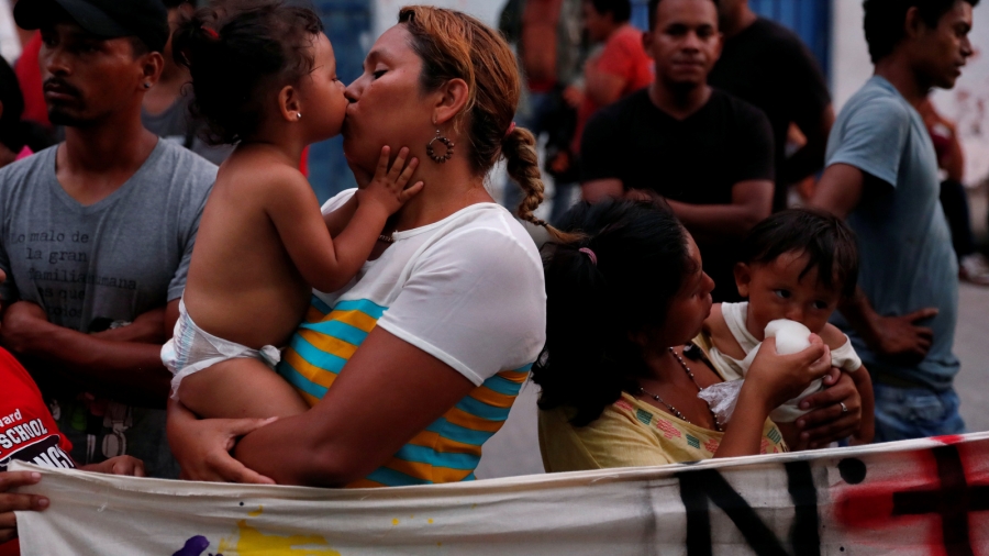 Nubia Reyes receives a kiss from her daughter Marcela Molina, 1, as they take part in a march to a local church to pray and receive blessings with many other members of a caravan traveling to the US, in Huixtla, Mexico Nov. 1, 2018. A mother receives a kiss from her toddler.