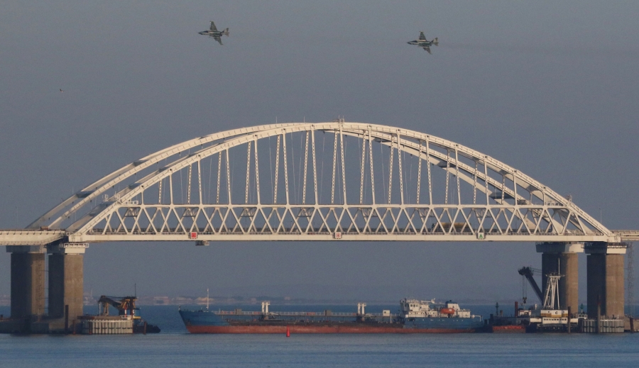 Russian jet fighters fly over a bridge connecting the Russian mainland with the Crimean Peninsula with a cargo ship beneath it. Russian jet fighters fly over a bridge connecting the Russian mainland with the Crimean Peninsula with a cargo ship beneath it