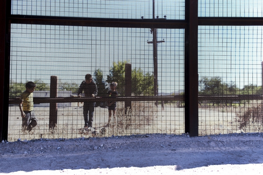 Mesh fencing with children behind, looking onto US side Mesh fencing with children behind, looking onto US side