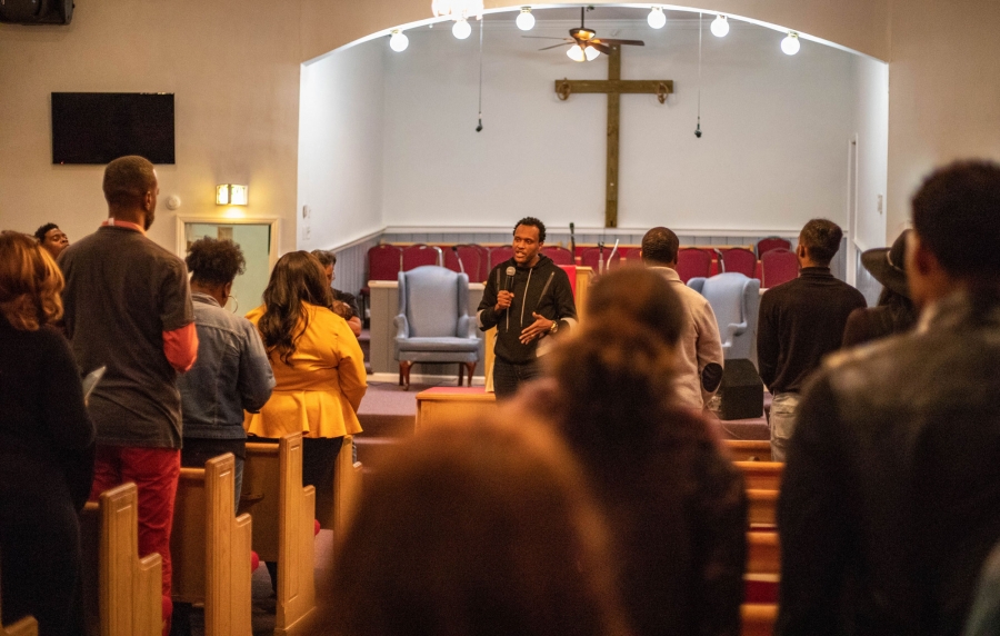 Rev. Antonio Grissom, of the Chapel Hill Baptist Church in Atlanta, leads a get-out-the-vote service at his church. Rev. Antonio Grissom is shown speaking with a microphone in hand to a group of people at the Chapel Hill Baptist Church.