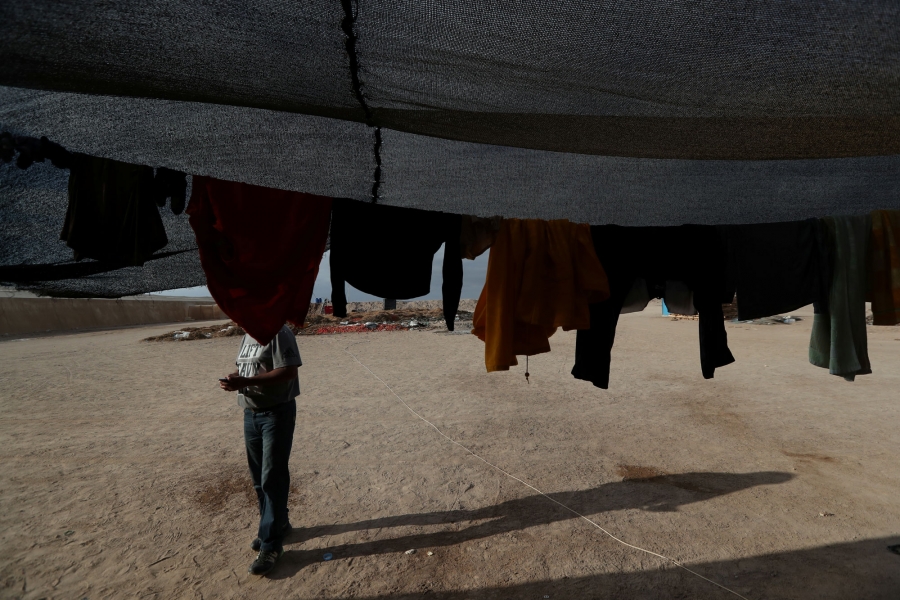 Undocumented Bolivian migrant known as Elvis, 40, uses a mobile phone after work. Undocumented Bolivian migrant is shown using a mobile phone and wearing jeans and a t-shirt.