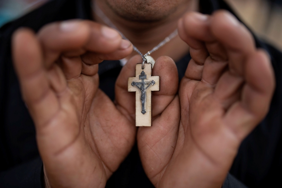 Nicolas Alonso Sanchez holds his cross. A close-up photography of Nicolas Alonso Sanchez holding his wooden cross.