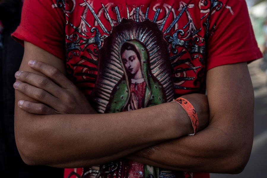 Herso, 17, from Honduras, wears a t-shirt depicting the Virgin of Guadalupe. Herso is shown wearing a red t-shirt depicting the Virgin of Guadalupe.