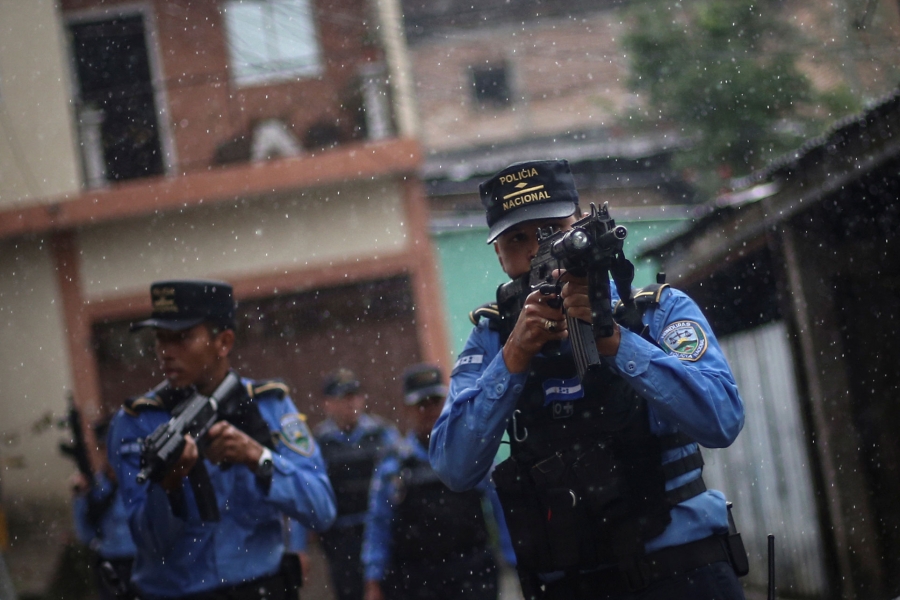 Police patrol in a neighborhood occupied by gangs known as El Hoyo. Several police officers are shown with high-powered riffles taking aim while on patrol .