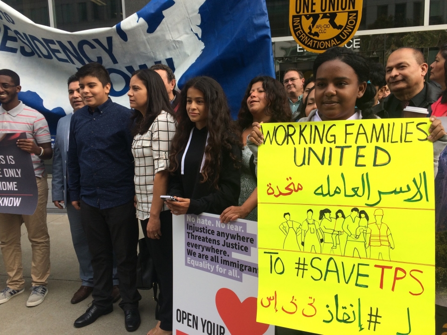Sara Ahmed, 12, holds a sign in English and Arabic before attending a court hearing in San Francisco on Sept. 26, 2018. Cristina Morales, Crista Ramos and other TPS supporters rally nearby. Sara Ahmed, 12, holds a sign in English and Arabic before attending a court hearing in San Francisco on Sept. 26, 2018. Cristina Morales, Crista Ramos and other TPS supporters rally nearby.