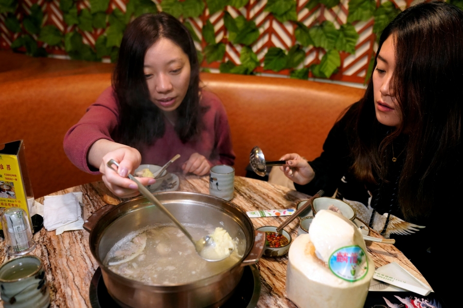 two women eating durian hot pot