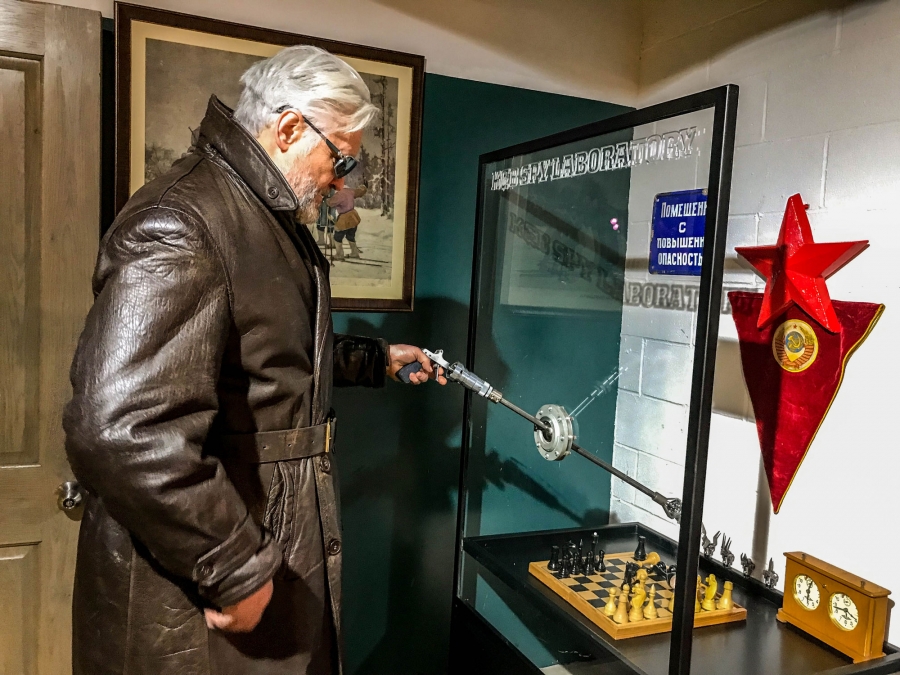 Julius Urbaitis demonstrates a device (reminiscent of arcade claw toy-grabber games) that KGB officers used to mix poison without contaminating themselves. Julius Urbaitis is shown demonstrating a device (reminiscent of arcade claw toy-grabber games) that KGB officers used to mix poison without contaminating themselves.