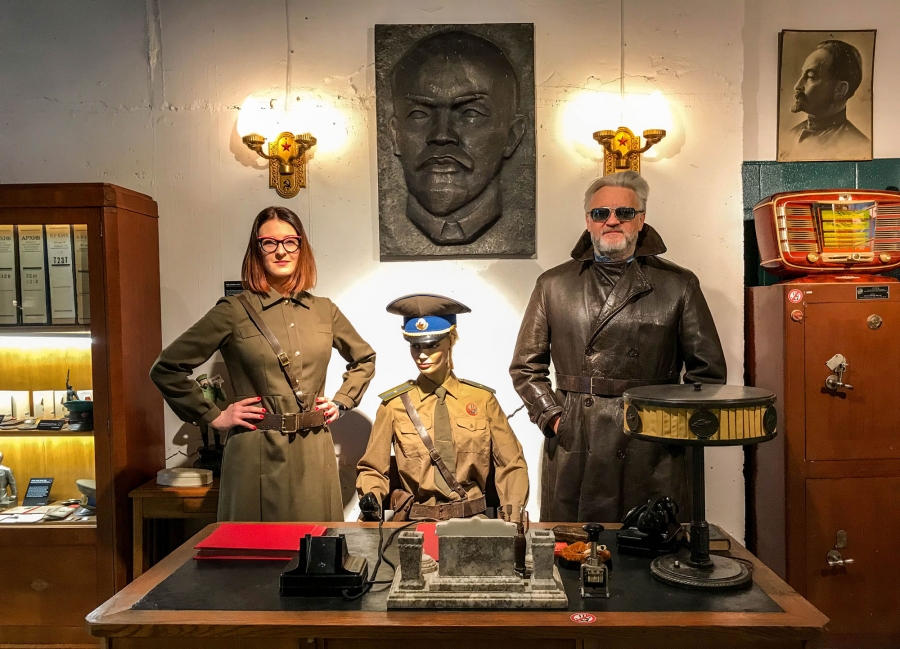 Father-daughter curators Julius and Agne Urbaityte pose by the desk of a KGB duty officer wearing vintage military attire Father-daughter curators Julius Urbaitis and Agne Urbaityte pose behind a desk of a mannequin KGB duty officer wearing vintage military attire.