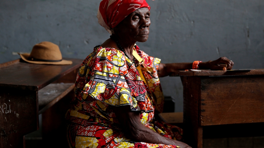 A woman wearing African textile dress sits in polling station in Kinshasa.