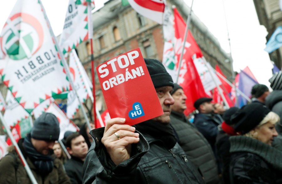 People take part in a protest against a proposed new labor law, billed as the "slave law," in Budapest, Hungary, Jan. 5, 2019. Protesters hold sign that says "Stop Orban."