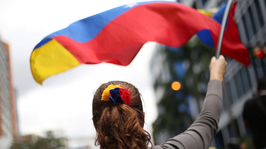 A woman waves red, blue and yellow flag.