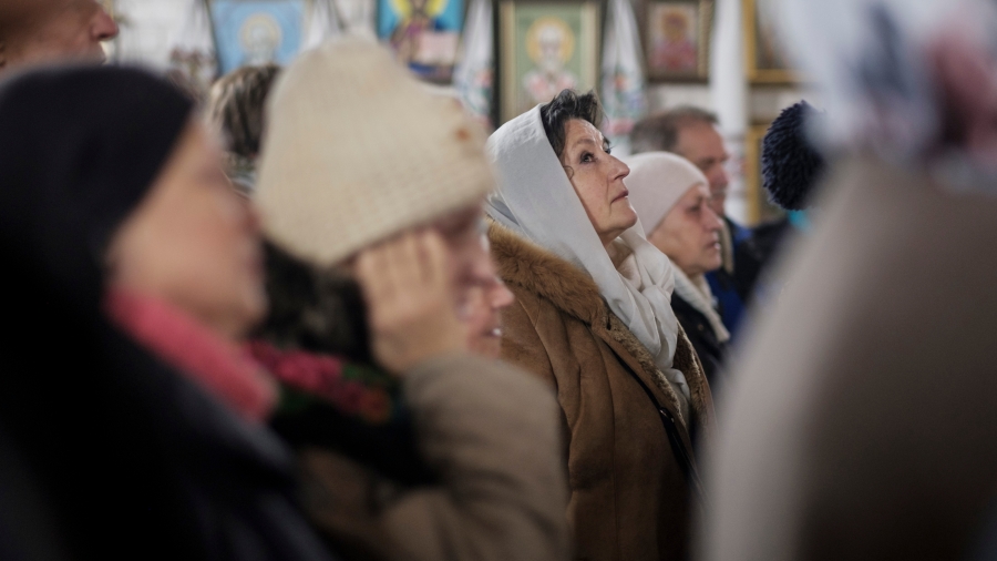 Worshippers at St. John the Theologian Cathedral in Kharkiv, Ukraine. A woman looks up while praying in church.