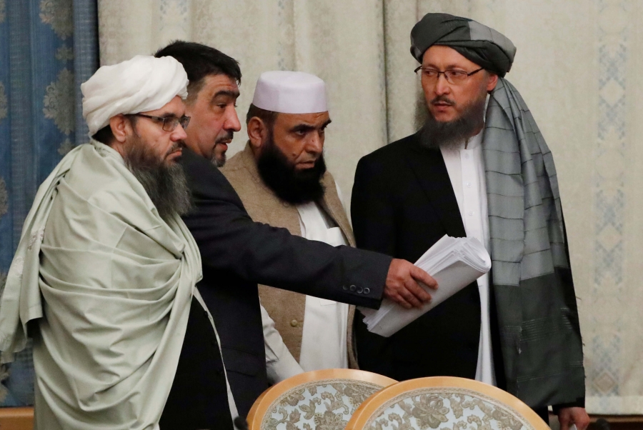 four men take seats at a long table