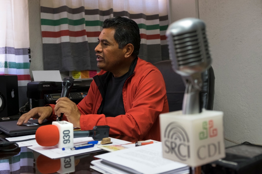 Melchor García López, director of La Voz de la Mixteca. A portrait photo of Melchor García López, shown wearing a red jacket and holding a microphone.