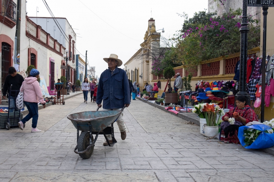 People head to work in the early morning hours in Tlaxiaco. People head to work in the early morning hours in Tlaxiaco including a man pushing a wheelbarrow in the nearground.