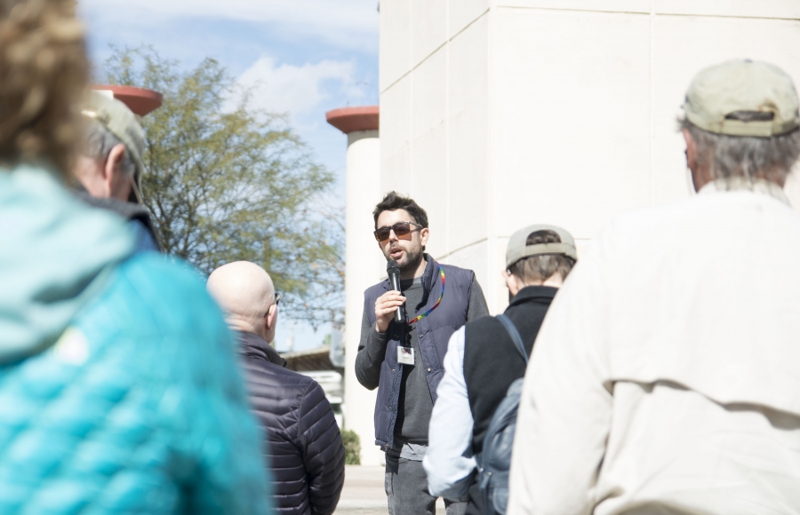 Alex La Pierre A man with a microphone talks to a small group