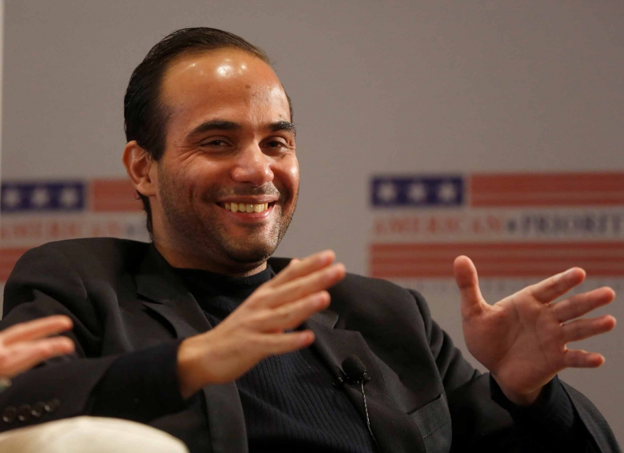 A man in a suit gestures with his hands