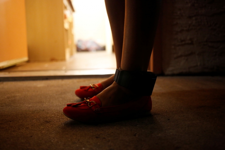 A Guatemalan woman shows her ankle monitor. A close-up photograph of a woman wearing an ankle monitor.