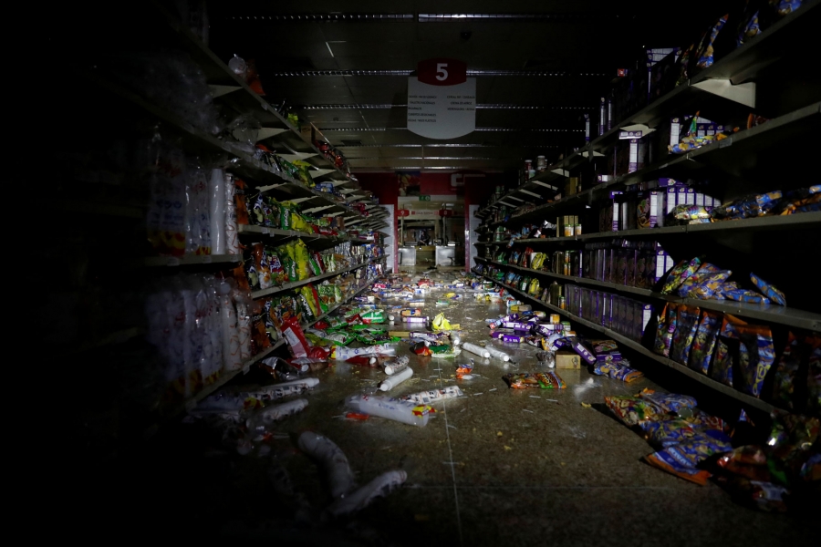 Damage is seen in a supermarket after it was looted in Caracas, Venezuela. The shelves of a market are shown with items thrown all over the floor after it was looted.