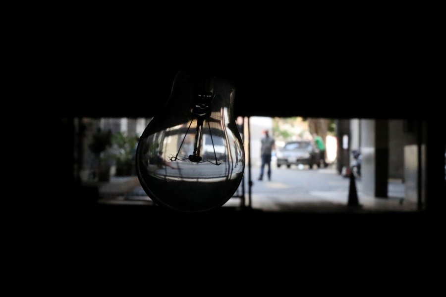 A view from inside private parking lots during a blackout in Caracas, Venezuela. A close-up photograph of a clear lightbulb without power.