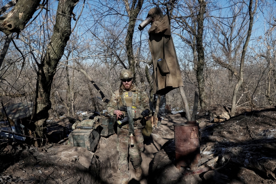 A member of Ukraine's interior ministry's Azov battalion, who has lost an eye and an arm A member of Ukraine's Azov battalion is shown wearing military fatigues, sunglasses and carrying a gun.