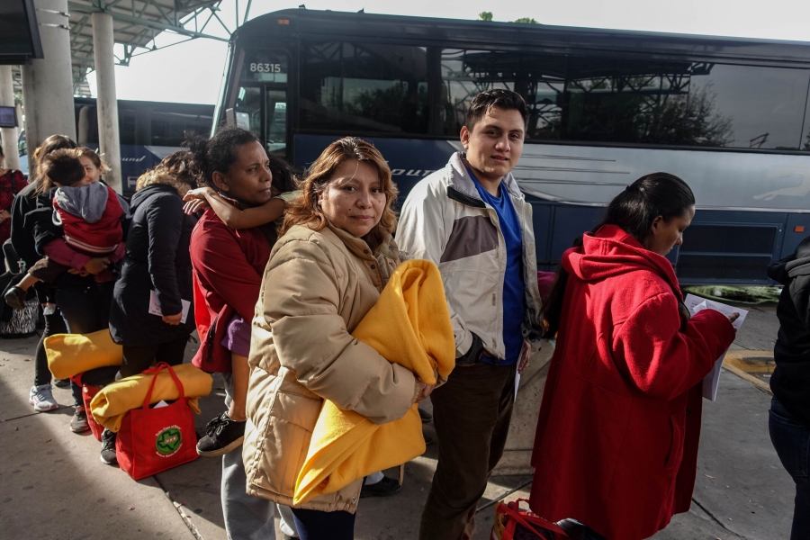 A migrant mother and son wait to board the bus at a bus station. A migrant mother and son wait to board the bus at a bus station.