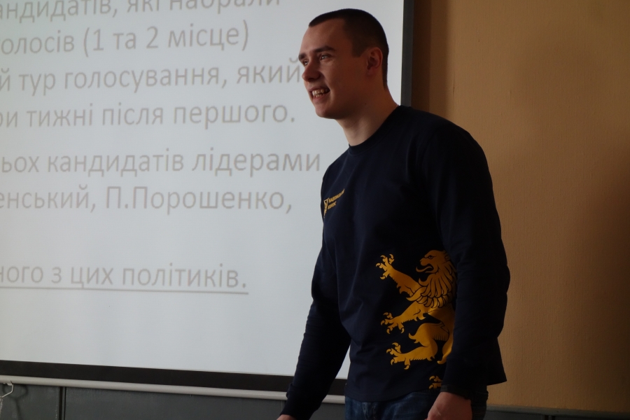 A man stands in front of a powerpoint.