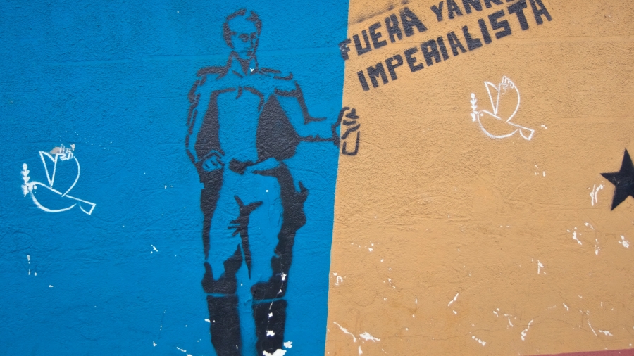A stencil of Simón Bolívar spray-painting "Out Imperialist Yankee."