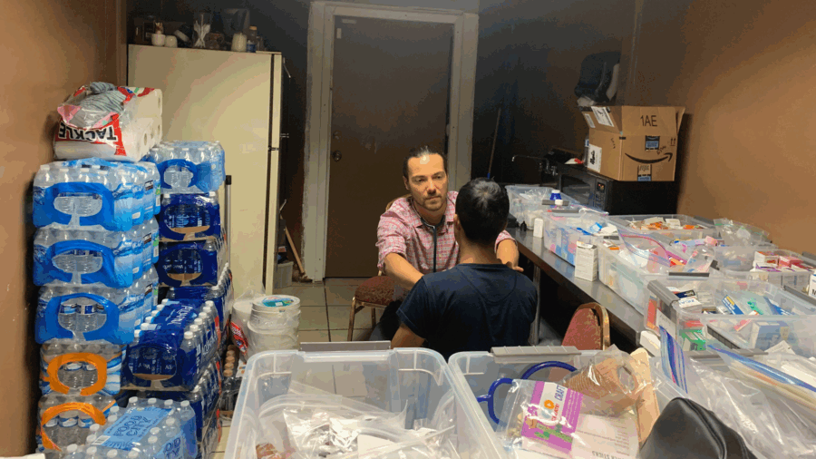 Surrounded by supplies, a doctor screens a boy
