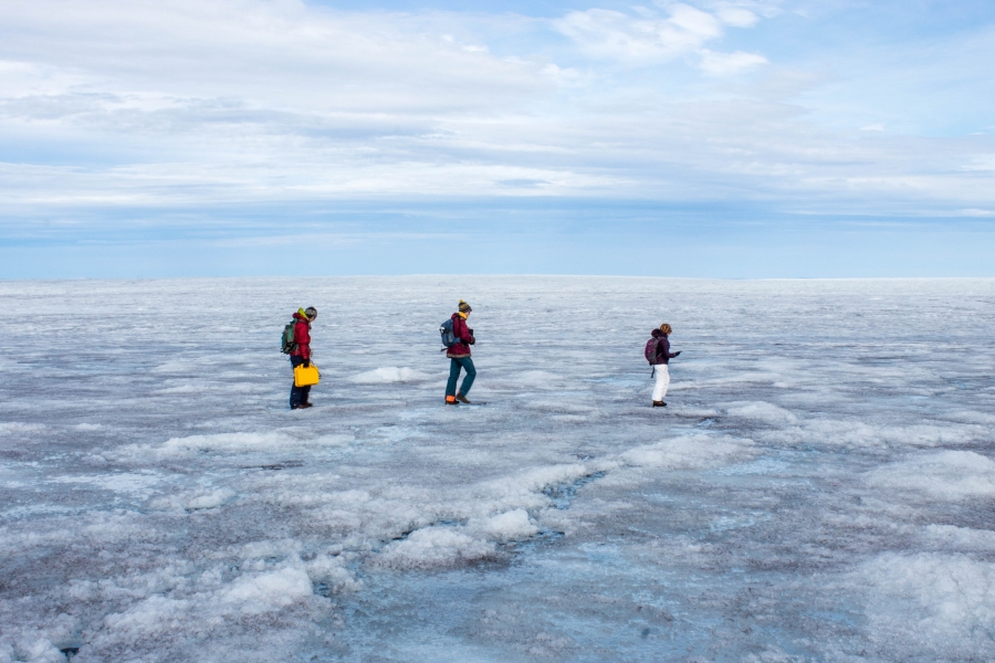 Team Radar at work. Students Rosie Leone, Aidan Stansberry and Ian MacDowell spent most of their five days on the ice using radar to map the bed — the rock and soil hundreds of feet below the ice sheet — which can affect the movement of the ice sheet. Students Rosie Leone, Aidan Stansberry and Ian MacDowell are shown bundled in artic-ready clothing and walking across the ice.