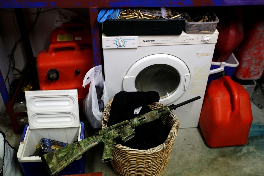 Noel Womersley's AR-15 semi-automatic rifle is seen in the garage of his house. An AR-15 semi-automatic rifle is seen painted in camoflage and sitting on a laundry basket.