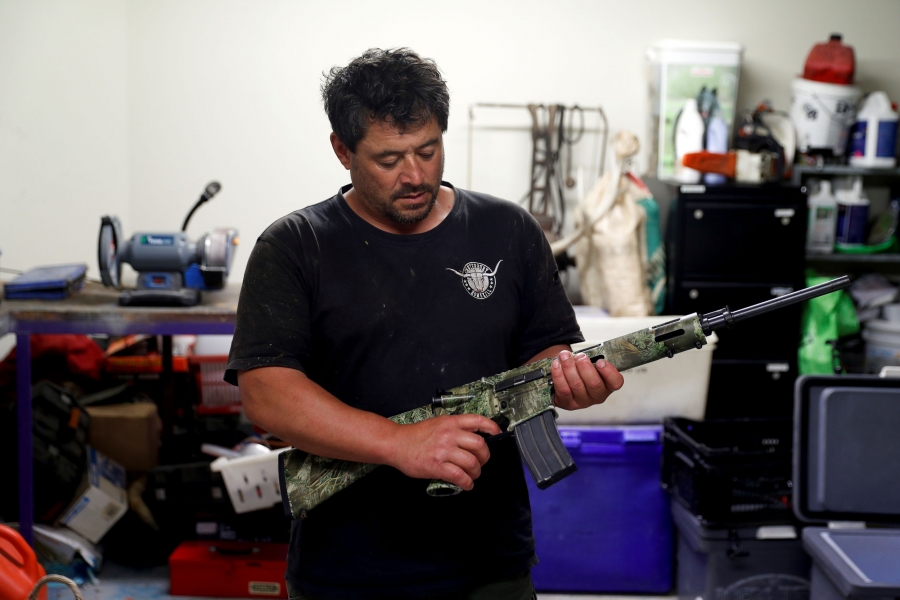 Noel Womersley stands with his AR-15 semi-automatic rifle. Noel Womersley is shown standing in a drak shirt holding his AR-15 semi-automatic rifle.