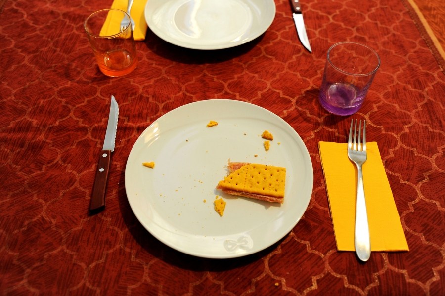 A snack is seen on the table of Carlo Spinazzi's kitchen, in his illegally occupied apartment. A cracker and peanut butter snack snack is seen on the table with a red table cloth.
