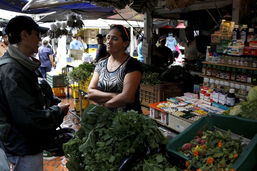 A vendor talks with a customer in her fruit and vegetables stall selling medicines at a market in Rubio, Venezuela. A vendor talks with a customer in her fruit and vegetables stall selling medicines at a market in Rubio, Venezuela.