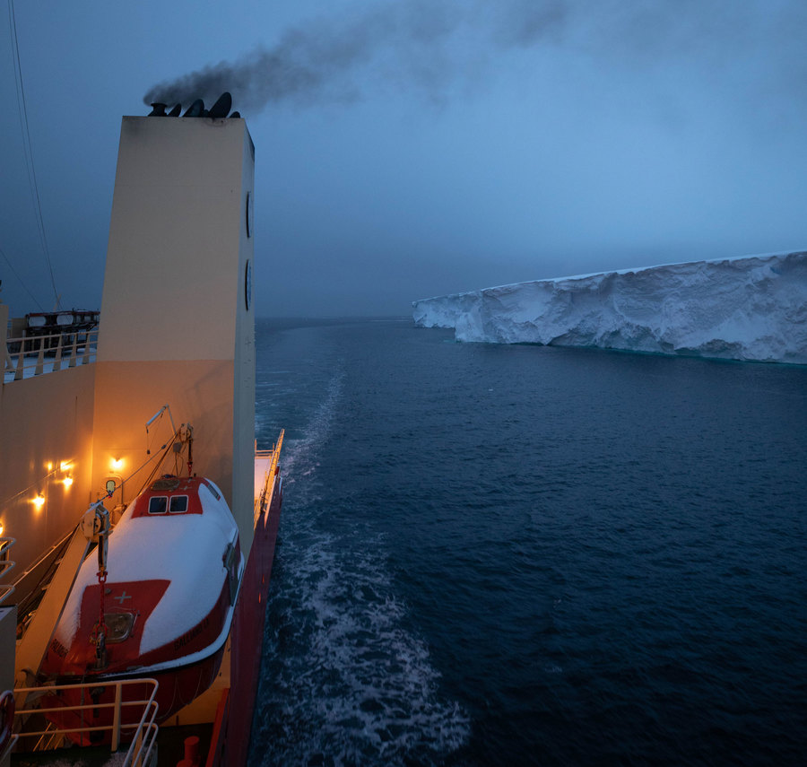 The Nathaniel B. Palmer navigates along the eastern tongue of Thwaites glacier. From the side of the vessel, the Nathaniel B. Palmer is shown with a smoke stack in the nearground, navigating along the eastern tongue of Thwaites glacier.