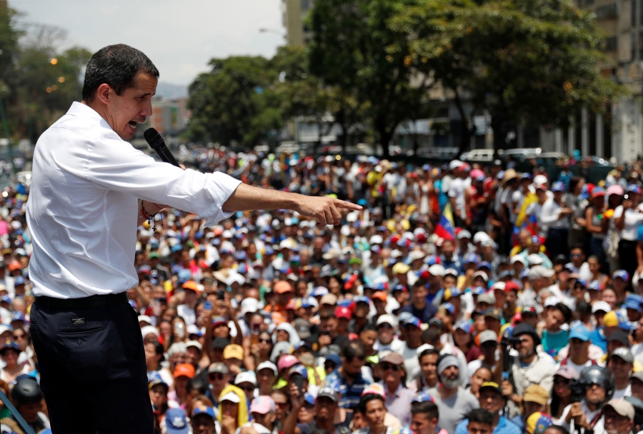 Venezuelan opposition leader Juan Guaidó gestures as he speaks to supporters Venezuelan opposition leader Juan Guaidó is shown in a white shirt and holding a microphone while gesturing to supporters