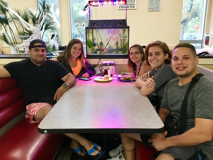 Five students at a dining table, sitting on benches