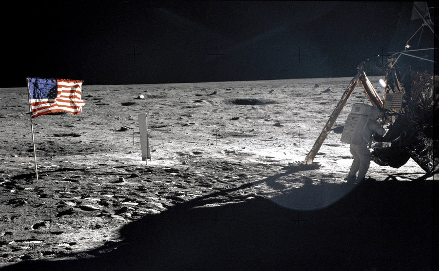 Astronaut Neil Armstrong stands next to the Lunar Module "Eagle" on the moon, July 20, 1969. A US flag is shown on the moon adjacent to the Lunar Module.