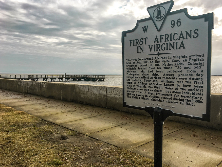 Fort Monroe sign A sign marking the arrival of the first enslaved Africans in front of a seascape.