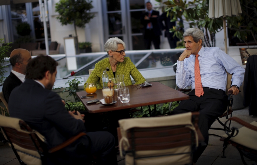 One woman and three men sit around a patio table