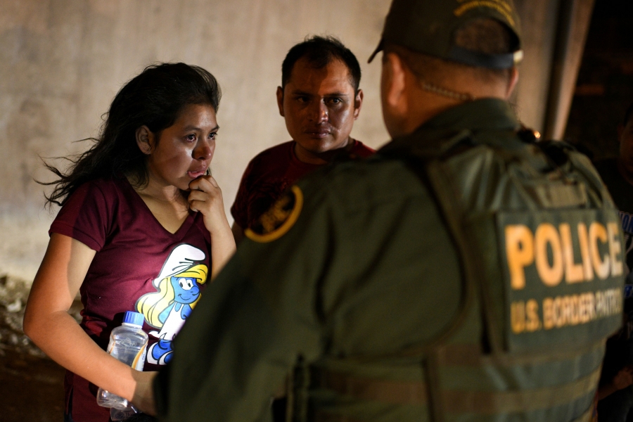 Thirteen-year-old Joseline, a Guatemalan migrant seeking asylum with father Jose Luis, cries after crossing the Rio Grande and turning herself in to US Border Patrol in Hidalgo, Texas, Aug. 23, 2019. A young girl is shown standing in front of a Border Patrol officer and crying.
