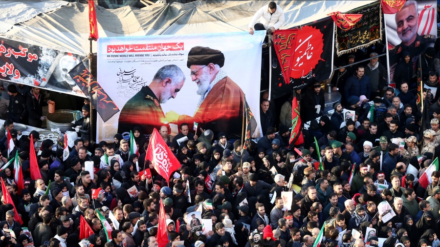 Iranian people attend a funeral procession A mass of people holding banners